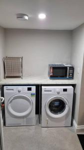 a laundry room with a washing machine and a microwave at Teachín na Siúire 