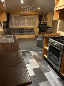 a kitchen and living room with a stove and a couch at AM bargain holidays at Withernsea sands in Withernsea