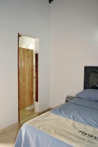 1 dormitorio con 1 cama y puerta de madera en Lago Manantial, en Independencia