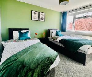 a bedroom with two beds and a window at Canvey Island Bliss By Artisan Stays I Free Parking I Bank Holiday Offer in Canvey Island
