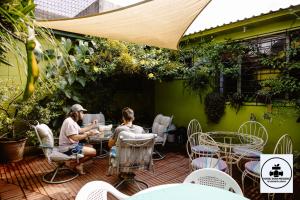 two people sitting at a table on a patio at Hostal Doña Mercedes in Juayúa