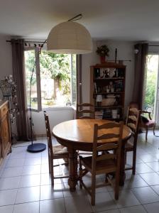 Maison 3 chambres avec jardinet في Ris-Orangis: غرفة طعام مع طاولة وكراسي خشبية