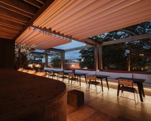 een patio met een rij tafels en stoelen bij Majagua Hotel Boutique -Adults Only in Oaxaca City