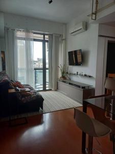 un soggiorno con un letto, un tavolo e una finestra di Volpi Residence na Savassi - charme, localização e conforto a Belo Horizonte