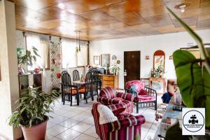 a living room with chairs and a dining room at Hostal Doña Mercedes in Juayúa