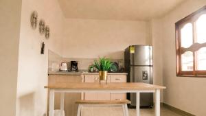 a kitchen with a table and a refrigerator at OCASSO JARDIN APARTAMENTO AZULEJO in Jardin