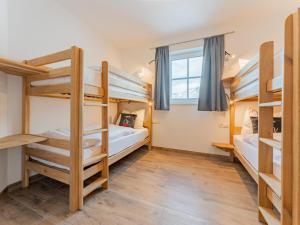 a room with three bunk beds and a window at Chalet Aquila in Niedernsill