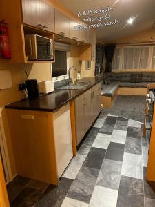 a kitchen with a sink and a couch in a room at AM bargain holidays at Withernsea sands in Withernsea