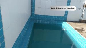 a swimming pool with a blue tiled floor at Praia do Foguete - Aluguel Econômico in Cabo Frio