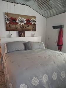 a bedroom with a white bed with flowers on the wall at The Butterfly Cabin with adjustable king-size bed. in Kempner