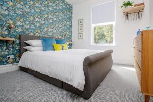 1 dormitorio con 1 cama grande con almohadas azules y amarillas en Flat 1 Highgate, Walford Road, Ross on Wye en Wilton