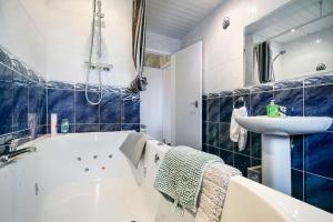 ein Badezimmer mit einer Badewanne und einem Waschbecken in der Unterkunft 2 Bed Apartment near Belfast & Ferry in Belfast