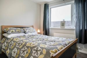 Schlafzimmer mit einem Bett und einem Fenster in der Unterkunft 2 Bed Apartment near Belfast & Ferry in Belfast