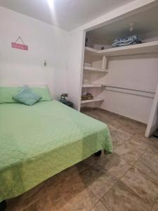 a bedroom with a green bed in a room at A pasos playa olas altas, Faro y Machado in Mazatlán