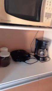 a kitchen counter with a coffee maker and a coffee pot at Hosthê compartilhados in Canoas