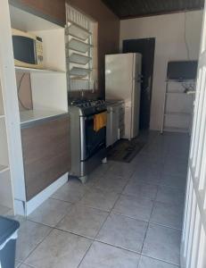 uma pequena cozinha com um frigorífico e um fogão em Hosthê compartilhados em Canoas
