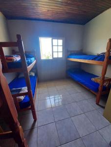 a room with three bunk beds and a window at Hosthê compartilhados in Canoas