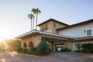 ein Gebäude mit Palmen davor in der Unterkunft Tommy Bahama Miramonte Resort & Spa in Indian Wells