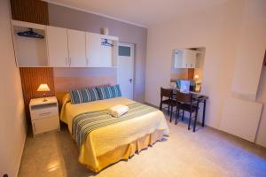 1 dormitorio con cama, escritorio y mesa en Abraham Complejo Turístico en San Rafael