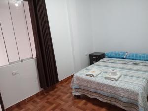 a bedroom with a bed with two towels on it at La Petite Maison in Nazca +32 photos