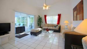 ein Wohnzimmer mit Sofa und Fernseher in der Unterkunft House Rainbow in Cape Coral
