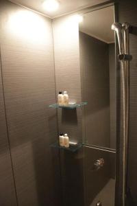 a bathroom with a shower with three shelves at 【都電屋203】标准间/都电荒川线/近三ノ輪/一线直达秋叶原/上野/浅草 in Tokyo