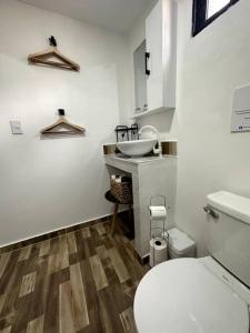 a bathroom with a white toilet and a sink at A hidden gem between sea and mountains in Santa Bárbara de Samaná