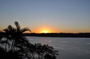 Una puesta de sol sobre un cuerpo de agua con una palmera. en Cabaña Santa Ana, en Santa Ana 27 fotos más