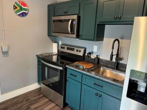 a kitchen with green cabinets and a sink and a microwave at The Sahara #3 in Bellefontaine