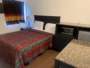 Habitación de hotel con cama y microondas en Encore Inn en Inglewood