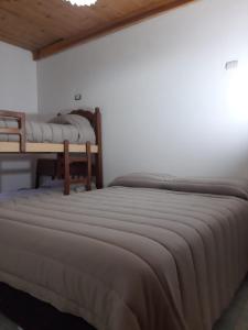 2 Betten in einem Zimmer mit weißen Wänden in der Unterkunft Sol y Luna 1 in Perito Moreno