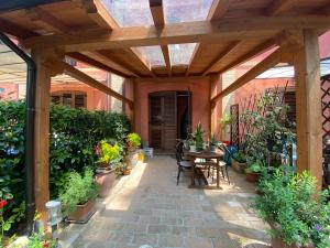 un patio con pérgola de madera y una mesa con plantas en Soggiorno da Fiore, en Monte Rubiaglio
