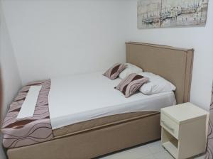 een kleine slaapkamer met een bed met een nachtkastje bij Villa MyDay in Budva