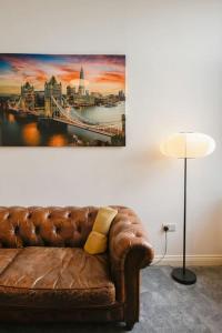 a couch in a room with a painting on the wall at Suite in the heart of Great Harwood in Great Harwood