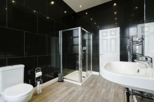 a bathroom with a toilet and a sink and a shower at Suite in the heart of Great Harwood in Great Harwood