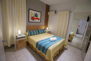 Habitación de hotel con cama y mesita de noche con cama sidx sidx sidx sidx en Abraham Complejo Turístico en San Rafael