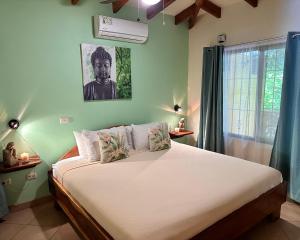 um quarto com uma cama num quarto com uma janela em The Inner Light Yoga Lodge em Sámara