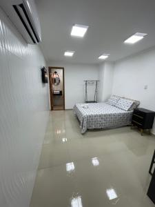 um quarto branco com duas camas em RM hospedagem unidade Gamboa em Cabo Frio