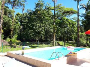a swimming pool in a yard with trees at Chacara Salmo 27 in Antonina