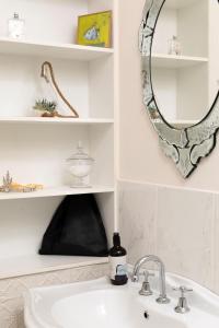 a bathroom sink with a mirror and a bottle of soap at Summerlands - Country Luxe in Alexandra