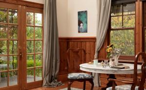 a room with a table and chairs and windows at Summerlands - Country Luxe in Alexandra