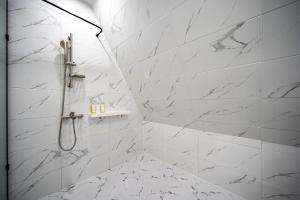 a bathroom with white marble walls and a shower at Cherryblossom in Changwon +67 photos