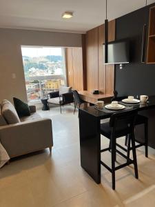 a kitchen and living room with a table and chairs at Conforto e sofisticação studio 1104, centro de JF in Juiz de Fora