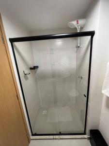 um chuveiro com uma porta de vidro na casa de banho em Conforto e sofisticação studio 1104, centro de JF em Juiz de Fora