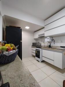 - une cuisine avec un bol de fruits sur un comptoir dans l'établissement Cobertura Duplex Na Praia Dos Milionários, à Ilhéus