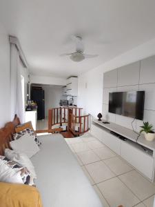 Il comprend un salon doté d'un canapé et d'une télévision à écran plat. dans l'établissement Cobertura Duplex Na Praia Dos Milionários, à Ilhéus