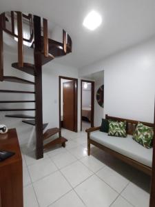 a living room with a couch and a staircase at Cobertura Duplex Na Praia Dos Milionários in Ilhéus