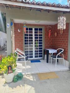 um pátio com duas cadeiras e uma mesa numa casa em Condomínio da Barra - Chalé 6B em Tamandaré