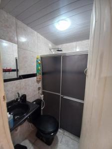 a bathroom with a black toilet and a sink at Condomínio da Barra - Chalé 6B in Tamandaré