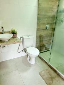 a bathroom with a toilet and a shower and a sink at Chalé Quinta Garden in Nova Friburgo